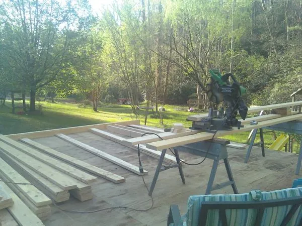 Miter saw and framing lumber on a deck under construction in Bristol